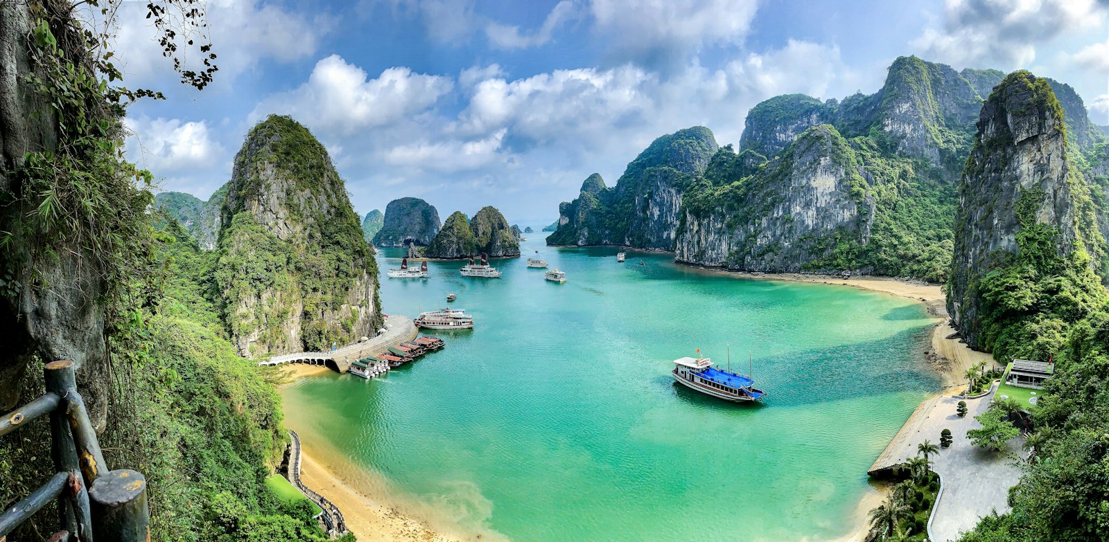 Crique de sable blanc et bateaux dans la baie de Ha Long