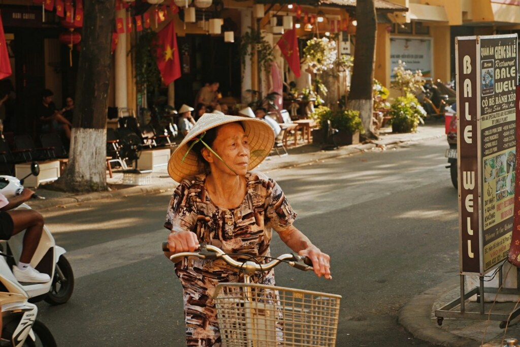Femme à bicyclette dans une rue de Hoi An, Vietnam