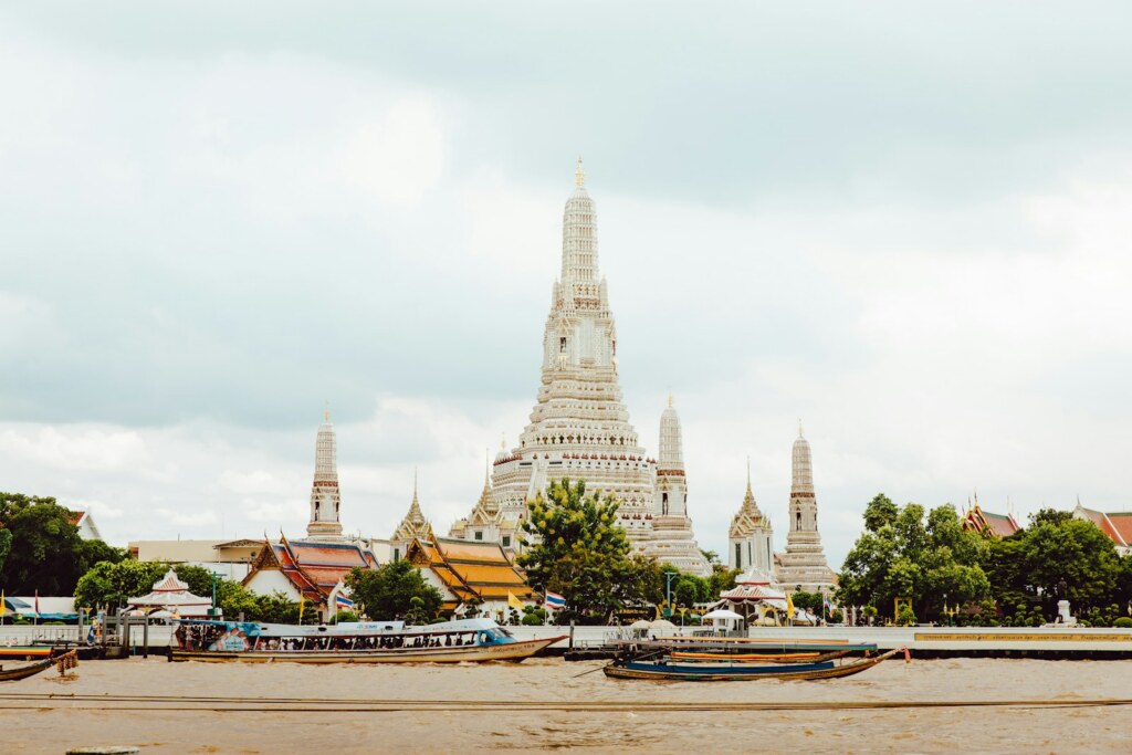 Le Wat Arun et ses prangs blancs au bord du fleuve Chao Phraya, Bangkok